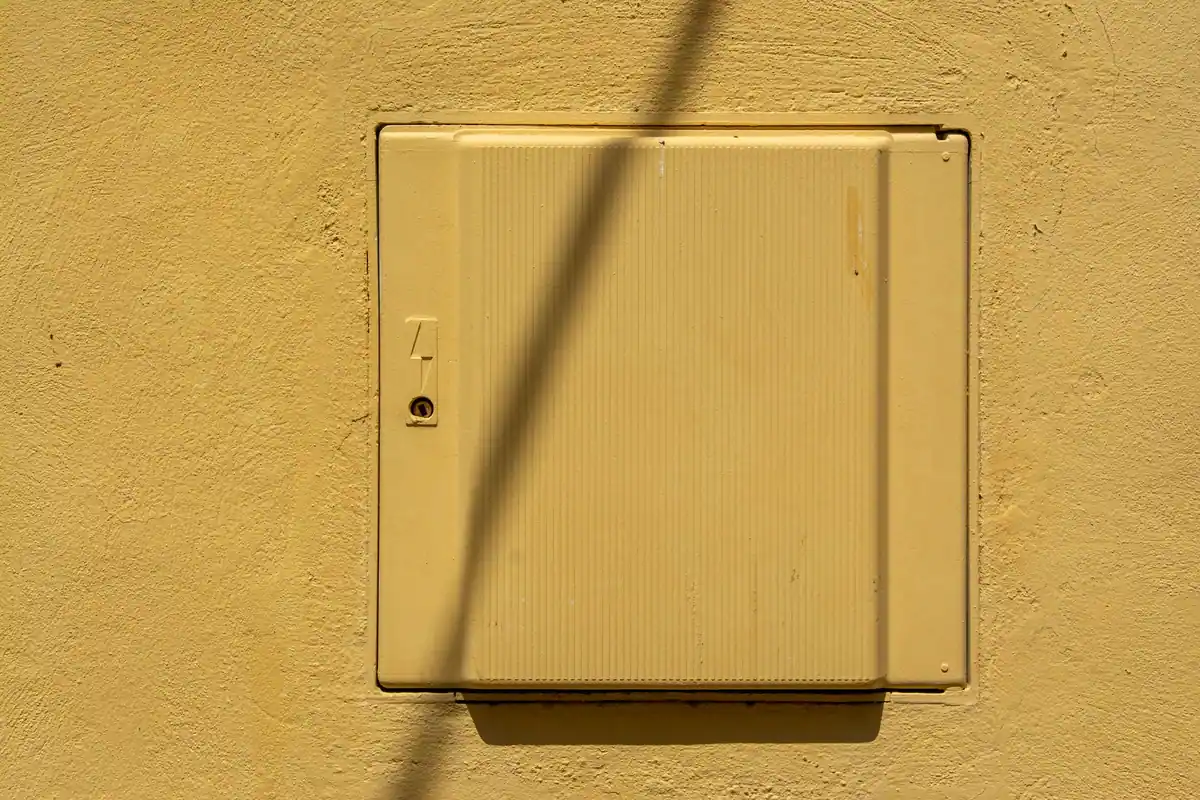 Caja eléctrica empotrada en la fachada de una vivienda, con la tapa pintada del color de la pared, uno de los puntos que revisa el electricista