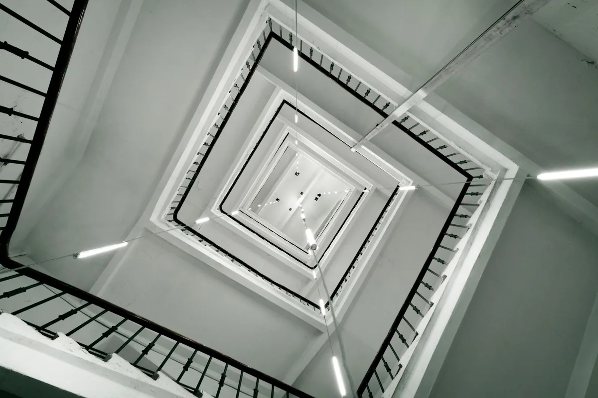 Hueco de escalera de un edificio de viviendas iluminado con luminarias LED lineales en las zonas comunes